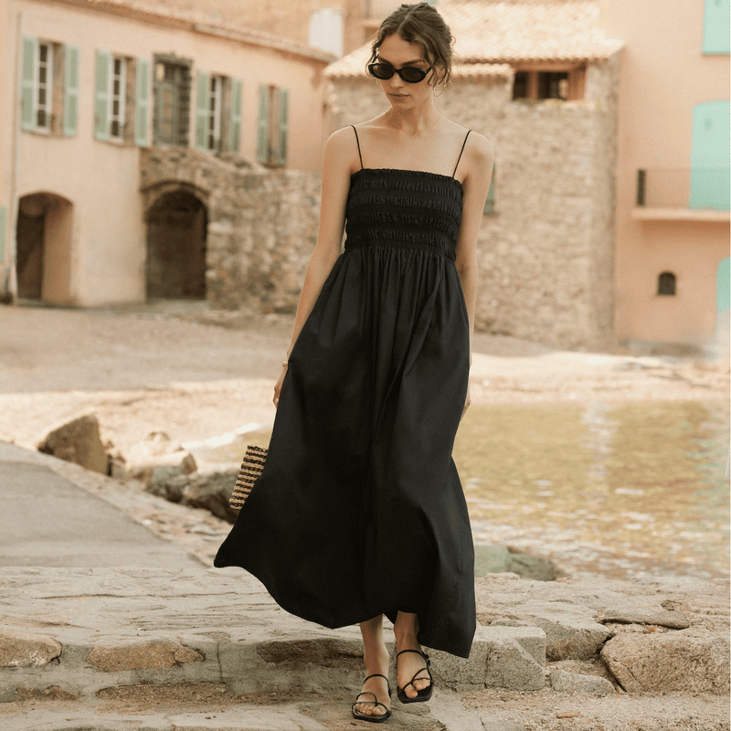 Image of woman walking on stone walkway with black flowy dress