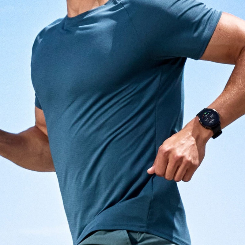 Man running with blue shirt on and Garmin watch visible on wrist