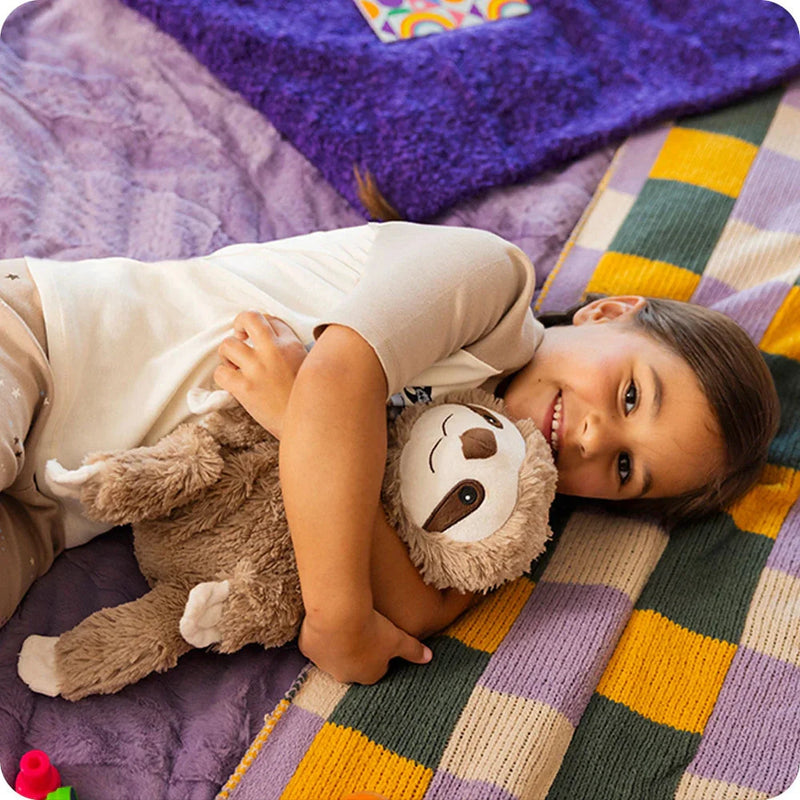 Girl laying on purple blanket holding koala warmies