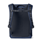 A YETI backpack shown from the back, featuring a dark navy blue padded main compartment with embossed branding, dark blue side panels, and black shoulder straps with silver reflective stitching, set against a plain white background.