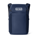A navy blue YETI backpack shown from the front on a clean white background, featuring a white YETI logo patch on the front pocket.